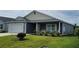 Lovely home featuring a well-maintained lawn, an attached garage, and an inviting front porch at 744 Barron Pl, The Villages, FL 32163