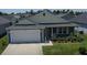 Inviting single-story home with two-car garage, landscaped lawn, and sidewalk at 744 Barron Pl, The Villages, FL 32163