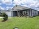 Charming single-story home with a well-maintained lawn and lush landscaping at 744 Barron Pl, The Villages, FL 32163
