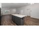 Spacious kitchen featuring dark cabinets, a large island with a light countertop, and hardwood style flooring throughout at 744 Barron Pl, The Villages, FL 32163