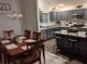 A modern kitchen features gray cabinets, stainless steel appliances, and a breakfast bar with chairs at 744 Barron Pl, The Villages, FL 32163