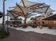Spacious outdoor dining area with shade structures, ideal for enjoying meals in a relaxed setting at 744 Barron Pl, The Villages, FL 32163