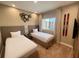 Cozy bedroom featuring two twin beds, modern decor, and a well-lit window at 7528 Brooklyn Dr, Kissimmee, FL 34747