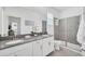 Bathroom with double sinks, gray countertops, and a glass-enclosed shower at 9175 Sommerset Hills Dr, Davenport, FL 33896