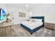 Well-lit bedroom features a plush blue bed, side table, and colorful artwork at 9175 Sommerset Hills Dr, Davenport, FL 33896