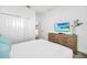 Bright bedroom featuring ample closet space, wood dresser, and a wall-mounted television at 9175 Sommerset Hills Dr, Davenport, FL 33896