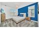 Comfortable bedroom featuring a queen bed, stylish lighting, and a vibrant accent wall at 9175 Sommerset Hills Dr, Davenport, FL 33896