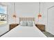 Bright bedroom showcasing a queen bed, modern pendant lights, and neutral decor at 9175 Sommerset Hills Dr, Davenport, FL 33896