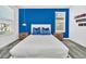 Bright bedroom with blue accents, hanging pendant lights, and a serene window view at 9175 Sommerset Hills Dr, Davenport, FL 33896
