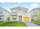 Charming two-story home with modern design, stone accents, landscaped yard and bright yellow garage door at 9175 Sommerset Hills Dr, Davenport, FL 33896