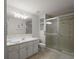Updated bathroom with a tiled shower, double vanity, and sleek lighting fixtures at 1105 Apple Ter, Leesburg, FL 34748