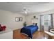 Comfortable bedroom with hardwood floors, a ceiling fan, and ample natural light at 1105 Apple Ter, Leesburg, FL 34748