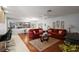 Open-concept living room featuring hardwood floors, comfortable couches, and lots of natural light at 1105 Apple Ter, Leesburg, FL 34748