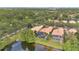 An aerial view of houses with screened-in pools backing onto a lake in a lush, green neighborhood at 11834 Gennaro Ln, Orlando, FL 32827