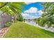 Scenic backyard view featuring lush green grass, a serene lake, and beautiful landscaping at 11834 Gennaro Ln, Orlando, FL 32827