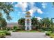 Elegant clubhouse with clock tower, beautiful landscaping, and brick paver driveway at 11834 Gennaro Ln, Orlando, FL 32827