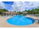 Large community pool with covered seating, palm trees and lounge chairs, perfect for relaxation and fun at 11834 Gennaro Ln, Orlando, FL 32827