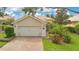 Charming home with a well-maintained lawn, mature landscaping, and a brick driveway at 11834 Gennaro Ln, Orlando, FL 32827
