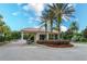 Community entrance with manned gate surrounded by palm trees and manicured landscaping at 11834 Gennaro Ln, Orlando, FL 32827