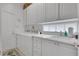 Bright laundry room featuring white cabinetry, a utility sink, and a modern washer and dryer at 11834 Gennaro Ln, Orlando, FL 32827