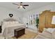 Bright main bedroom with wood floors, a ceiling fan, white walls, and windows with wooden shutters at 11834 Gennaro Ln, Orlando, FL 32827