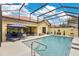 Gorgeous pool with a screen enclosure, sun loungers, and a lush green backyard with blue skies above at 11834 Gennaro Ln, Orlando, FL 32827