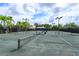 Wide view of outdoor tennis courts surrounded by towering palm trees on a bright and sunny day at 11834 Gennaro Ln, Orlando, FL 32827