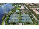 Aerial view of the tennis courts and pool area with lush trees, parking, and lake nearby at 11834 Gennaro Ln, Orlando, FL 32827