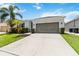 Charming single-Gathering home with a well-manicured lawn, a two-car garage, and tropical landscaping at 12084 Sumter Dr, Orlando, FL 32824