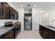 Modern kitchen featuring stainless steel appliances, granite countertops, and stylish dark wood cabinets at 12084 Sumter Dr, Orlando, FL 32824