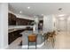 Modern kitchen with dark wood cabinets, granite countertops, and stainless steel appliances with a central island at 12084 Sumter Dr, Orlando, FL 32824