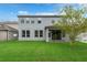 Backyard view of a two-story home with a covered patio and lush green lawn at 1270 Fountain Coin Loop, Orlando, FL 32828