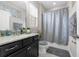 Elegant bathroom featuring granite countertops, dark cabinetry, and a shower with decorative curtain at 1270 Fountain Coin Loop, Orlando, FL 32828