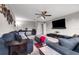 Spacious living room featuring modern sofas, a ceiling fan, and a large tv with natural light at 1270 Fountain Coin Loop, Orlando, FL 32828