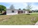 Side view of a single-story home featuring white stucco, brick accents, and a green lawn at 1432 Findlay St, Deltona, FL 32725