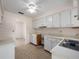 Clean kitchen with white cabinets, tile floors, and a pass-through window to another room at 1432 Findlay St, Deltona, FL 32725