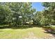Large, shaded backyard with a mix of grassy areas and mature trees for a private and natural setting at 1502 W 16 Th Street, Sanford, FL 32771