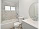 Bathroom with white tiled shower and tub, toilet, and gray vanity with oval mirror at 1502 W 16 Th Street, Sanford, FL 32771