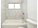 Bathroom featuring a white tiled shower and tub with a shower head and window at 1502 W 16 Th Street, Sanford, FL 32771