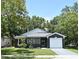 Charming single-story home with a well-manicured lawn and a one-car garage, set amidst lush green trees at 1502 W 16 Th Street, Sanford, FL 32771