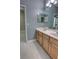 Bathroom featuring a double vanity, modern fixtures, and white wood-look flooring at 1528 Langham Ter, Lake Mary, FL 32746