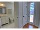 Hall bathroom with an updated vanity, wood-look flooring, and a door to the pool area at 1528 Langham Ter, Lake Mary, FL 32746