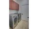 Laundry room featuring front loading washer and dryer, tile flooring, and a storage cabinet at 1528 Langham Ter, Lake Mary, FL 32746