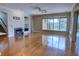 Bright living room featuring hardwood floors, a fireplace, built-in shelving, and a large window with pool views at 1528 Langham Ter, Lake Mary, FL 32746