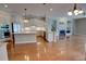 Bright kitchen and living room featuring white cabinetry, stainless steel appliances, hardwood floors, and fireplace at 1528 Langham Ter, Lake Mary, FL 32746