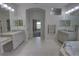 Main bathroom featuring dual sinks, granite countertop, a soaking tub and walk-in closet at 1528 Langham Ter, Lake Mary, FL 32746