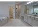 Main bathroom showcasing a walk-in shower, vanity, bathtub and walk-in closet at 1528 Langham Ter, Lake Mary, FL 32746