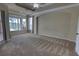 Carpeted main bedroom with screened-in porch access and a view of the backyard at 1528 Langham Ter, Lake Mary, FL 32746