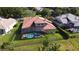 Aerial view of a private screened-in pool and patio with a terracotta tile roof, surrounded by a lush green yard at 1528 Langham Ter, Lake Mary, FL 32746