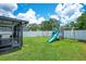 Spacious backyard featuring a screened-in patio, playground, green lawn, and white vinyl fence at 1531 Tiverton Blvd, Winter Garden, FL 34787